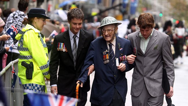 A Digger is flanked by two young men displaying the medals of a relatives in the Anzac Day Parade, 2011.